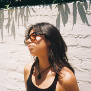 Woman wearing SAD Eyewear Ash premium square sunglasses in black with tinted bronze UV protection lenses