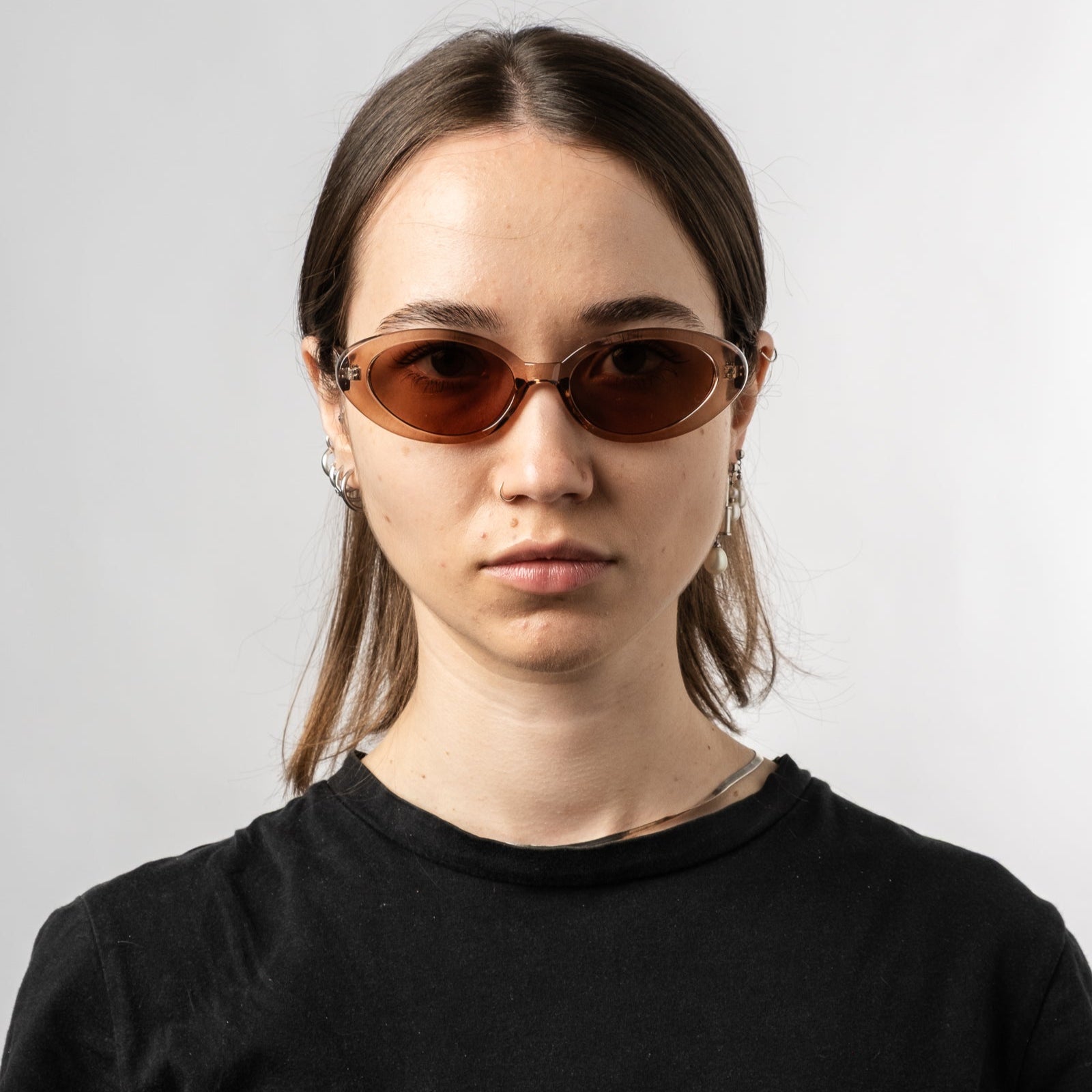 Female wearing Sad Eyewear Bloom oval sunglasses in rose with UV protection lenses