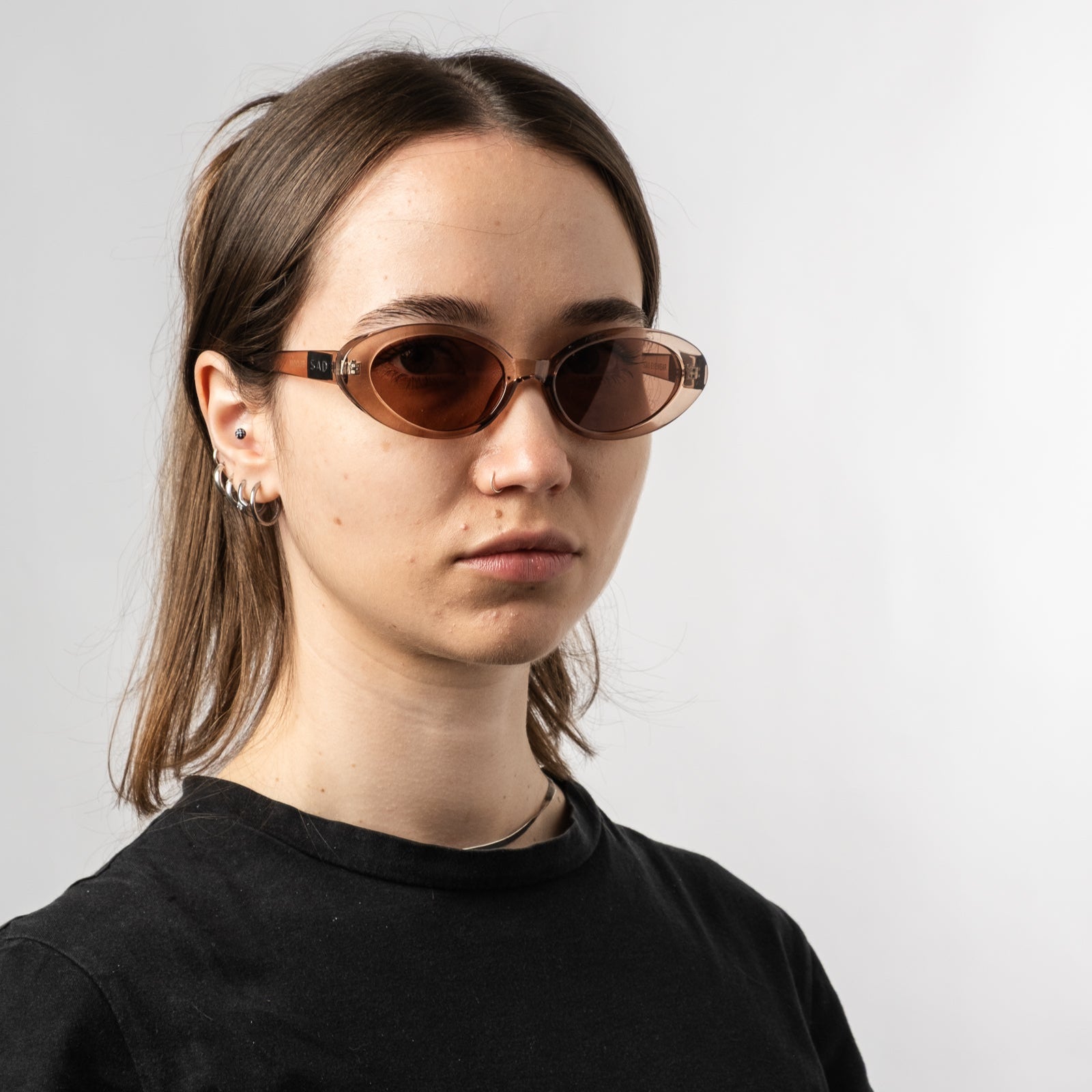 Female wearing Sad Eyewear Bloom oval sunglasses in rose with UV protection lenses