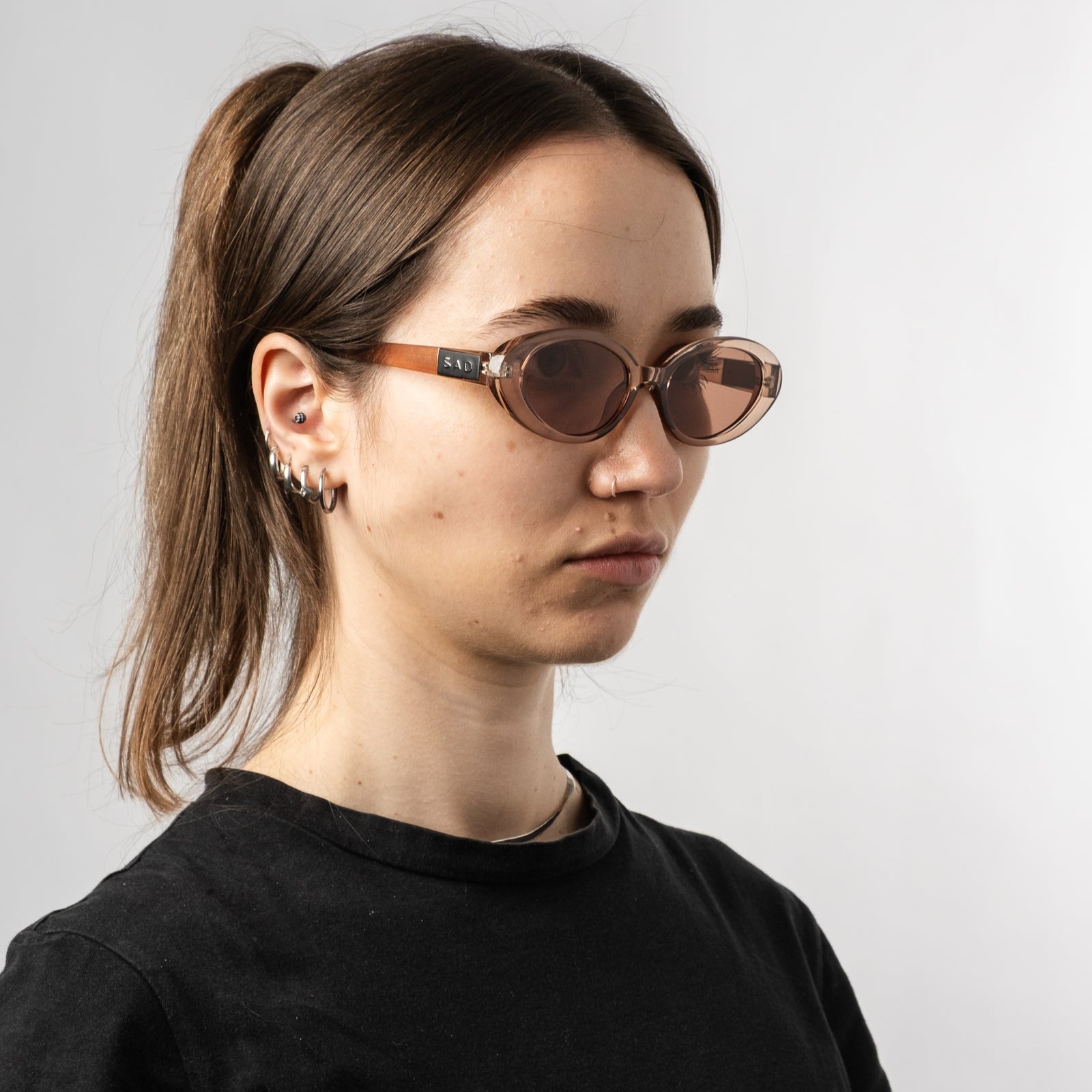 Female wearing Sad Eyewear Bloom oval sunglasses in rose with UV protection lenses