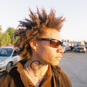 Person with styled hair and sunglasses in a parking lot, Heat Polarized Bronze sunglasses
