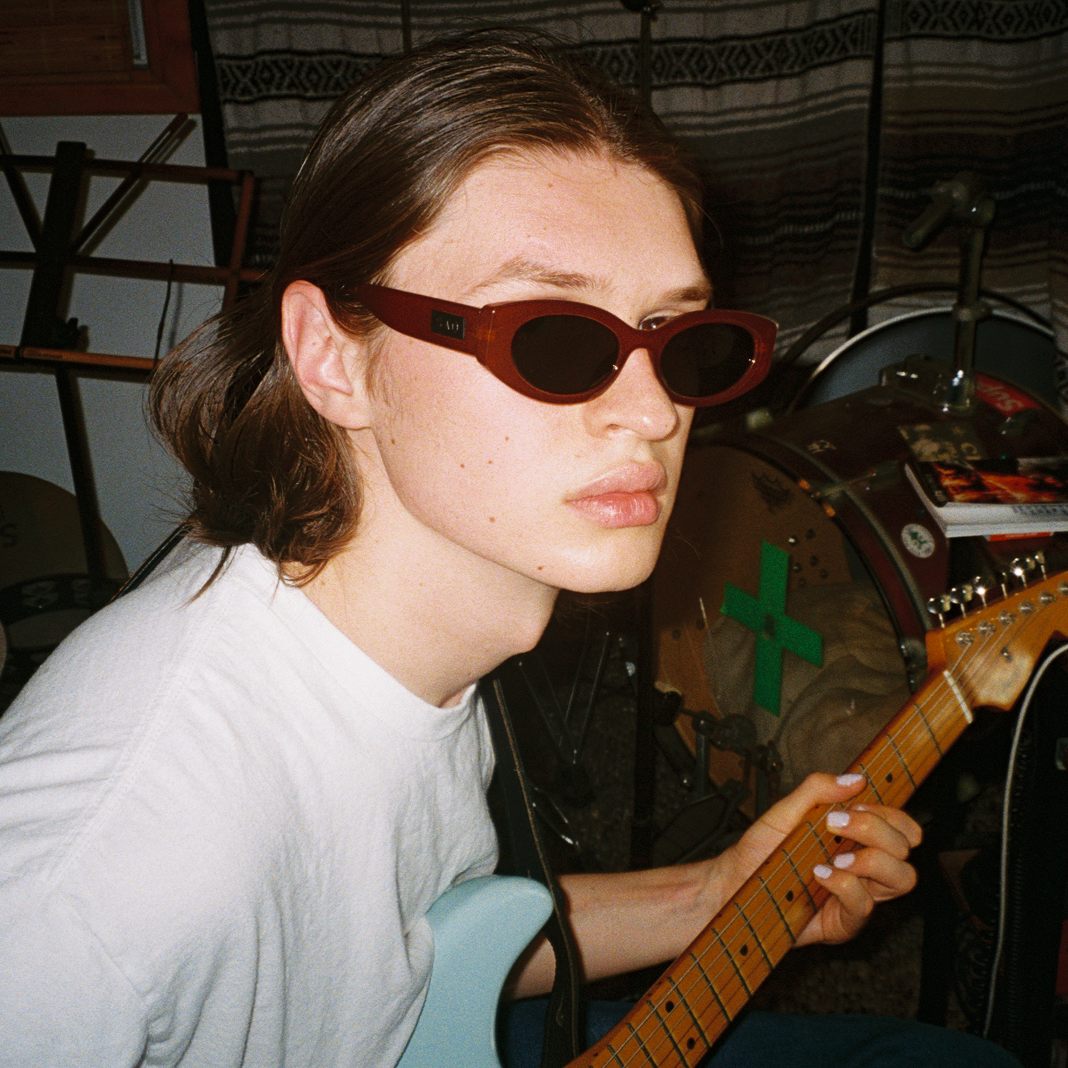 Person playing guitar in a room with musical equipment