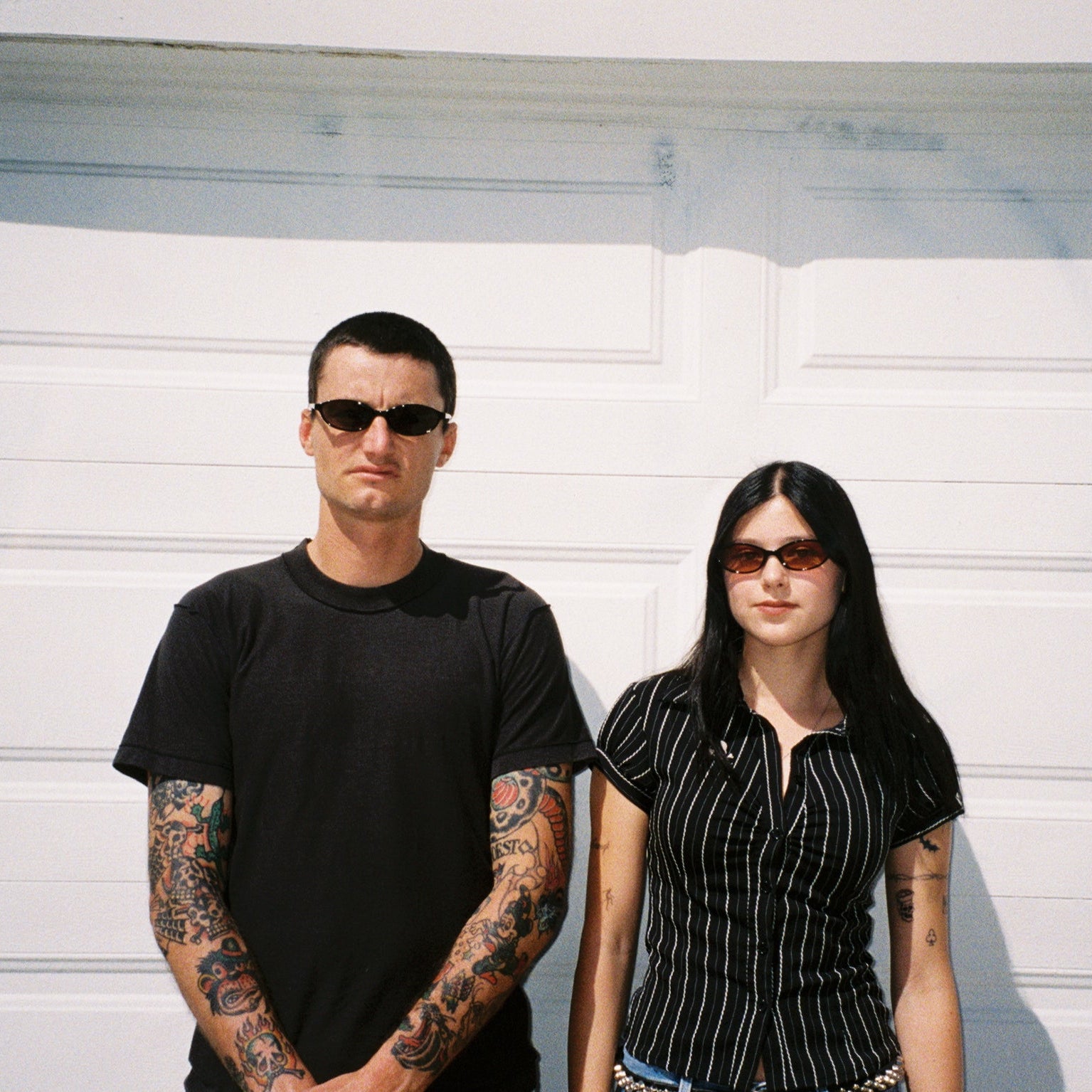 Macey Lemus and Zachary Kovacs wearing SAD Eyewear Celeste oval sunglasses in black with polarized grey UV protection lenses