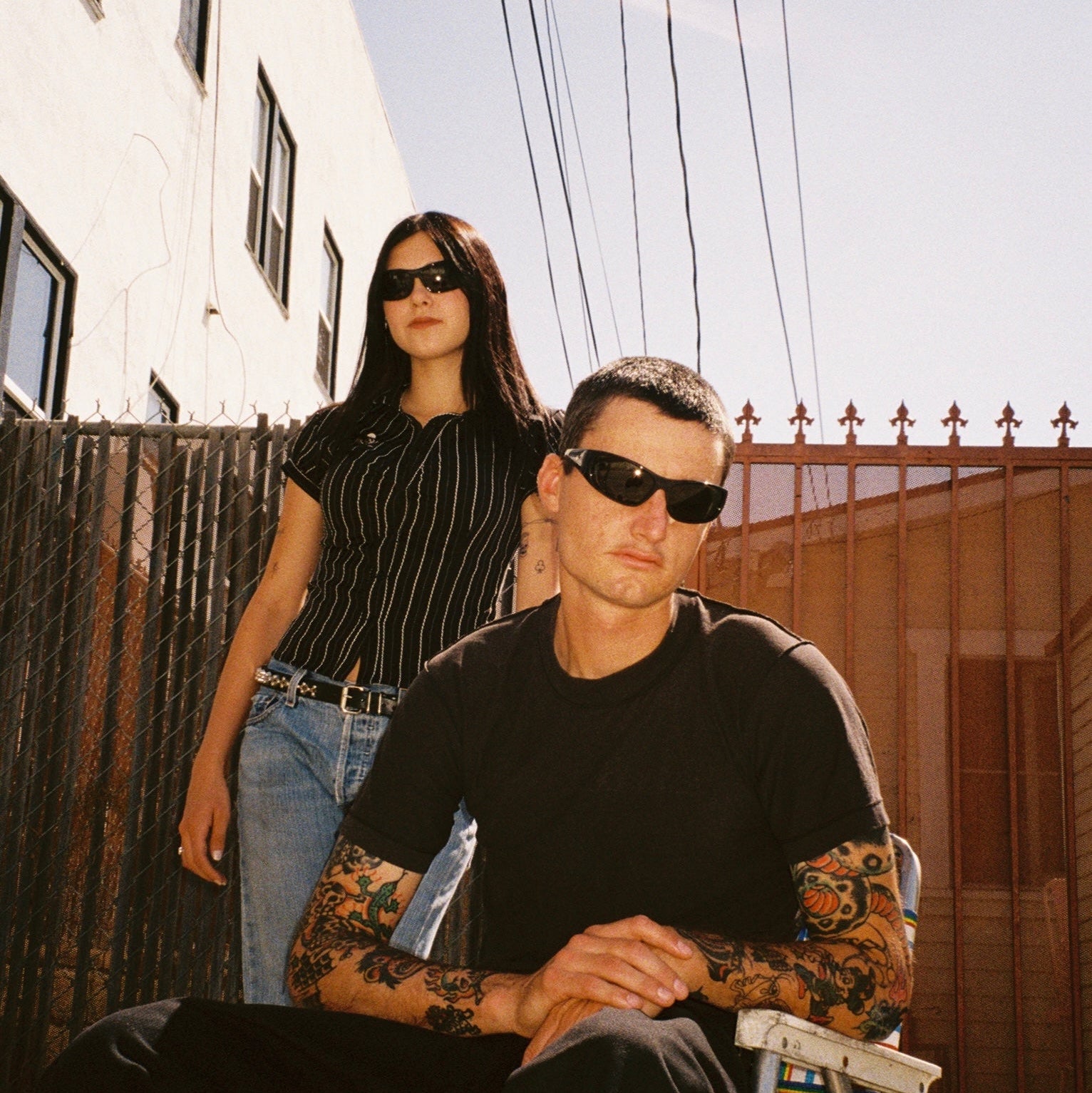 Macey Lemus and Zachary Kovacs wearing SAD Eyewear Fade wrap around sunglasses in black with polarized olive UV protection lenses